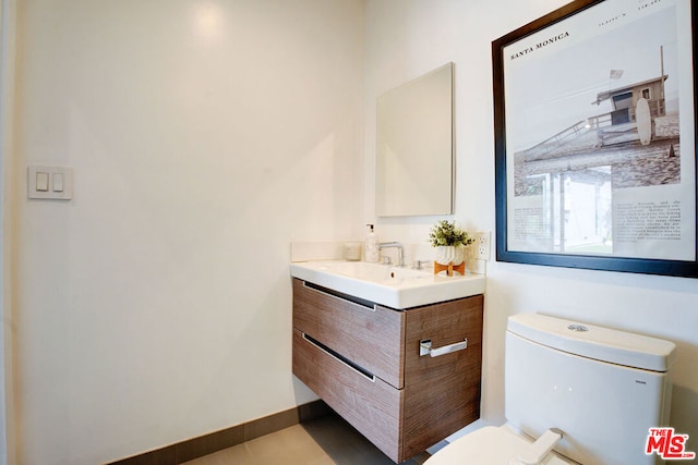 bathroom with vanity, tile patterned floors, and toilet