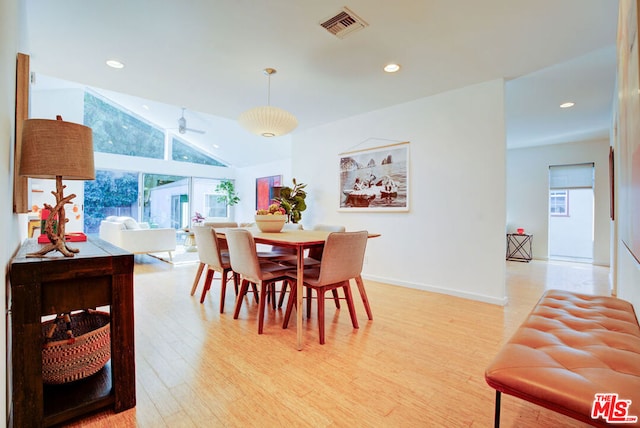 dining space with vaulted ceiling, light hardwood / wood-style flooring, and a wealth of natural light