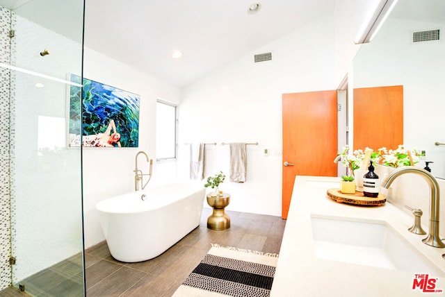 bathroom featuring vanity, vaulted ceiling, and plus walk in shower