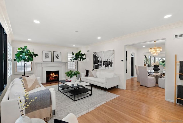 living room with a chandelier, ornamental molding, and wood-type flooring