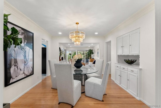 dining room featuring ornamental molding, a notable chandelier, and light wood-type flooring