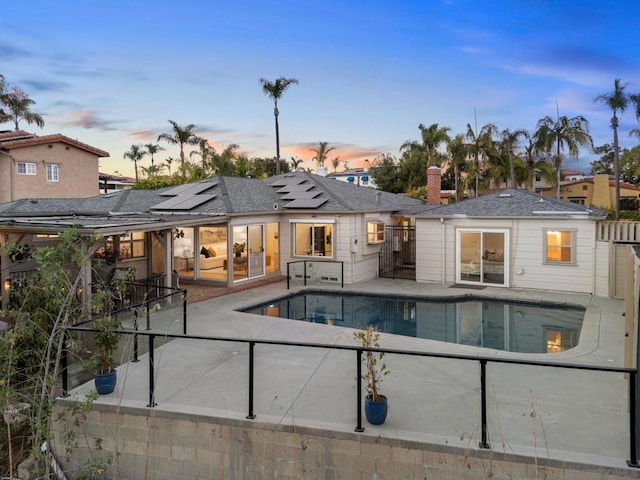 pool at dusk with a patio area