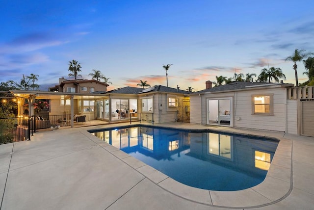 pool at dusk featuring a patio