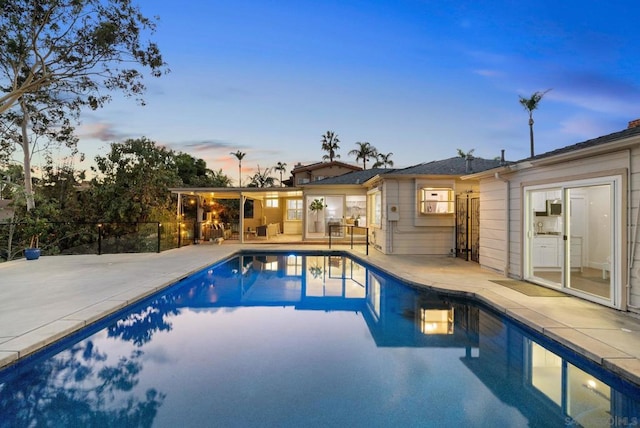 pool at dusk with a patio