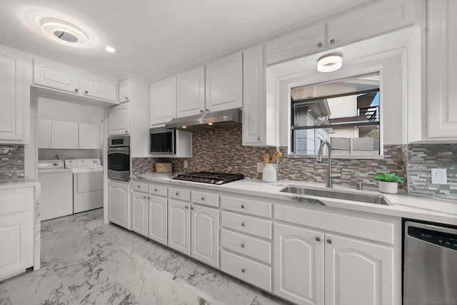 kitchen with decorative backsplash, sink, white cabinetry, washer and clothes dryer, and appliances with stainless steel finishes