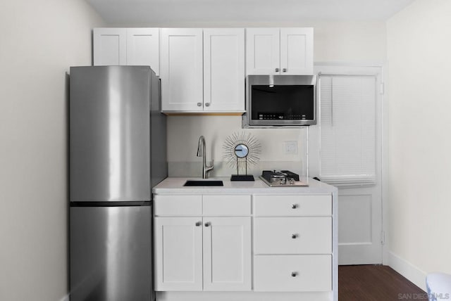 kitchen featuring sink, white cabinets, dark hardwood / wood-style floors, and stainless steel appliances