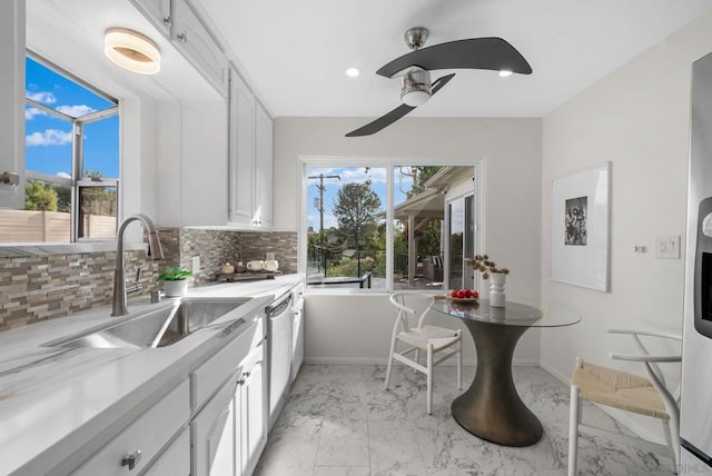 kitchen featuring white cabinetry, ceiling fan, decorative backsplash, dishwasher, and sink