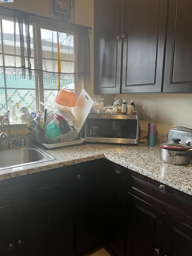 kitchen featuring a healthy amount of sunlight, sink, and dark brown cabinetry