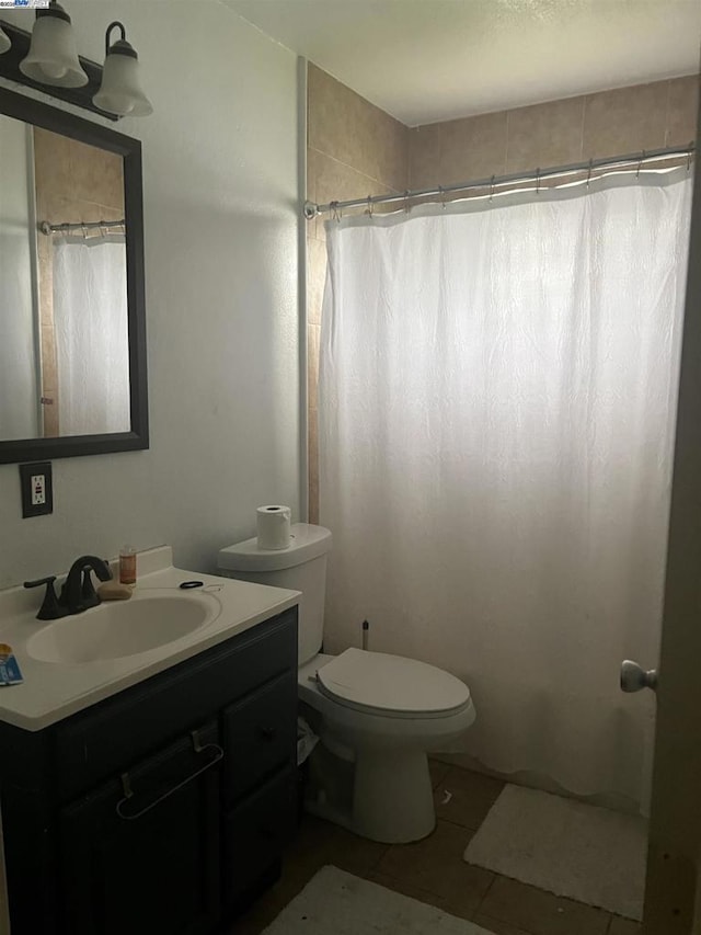 bathroom with toilet, vanity, tile patterned floors, and curtained shower