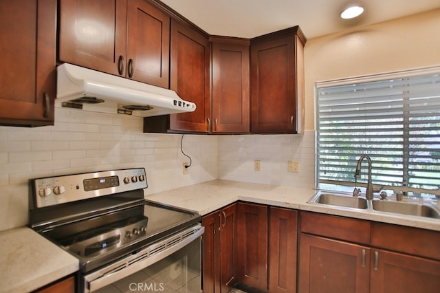 kitchen featuring stainless steel electric stove, recessed lighting, decorative backsplash, a sink, and under cabinet range hood