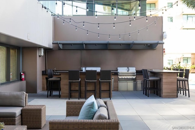 view of patio / terrace with an outdoor kitchen, an outdoor living space, exterior bar, and area for grilling