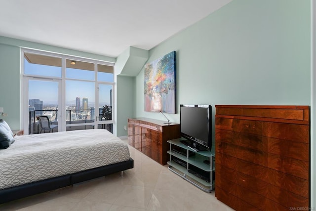 bedroom with access to exterior and a wall of windows