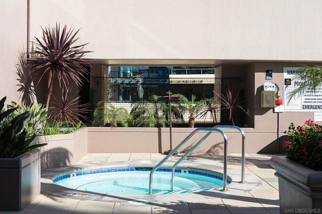 view of swimming pool with a hot tub