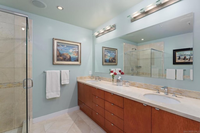 bathroom with a shower with shower door, vanity, and tile patterned floors