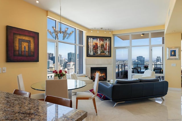 living room with rail lighting, a fireplace, plenty of natural light, and a notable chandelier