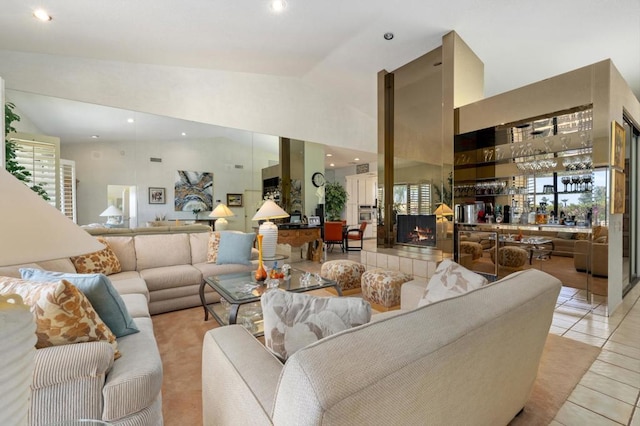 tiled living room with a tiled fireplace and high vaulted ceiling