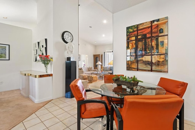 dining space featuring light carpet and a high ceiling