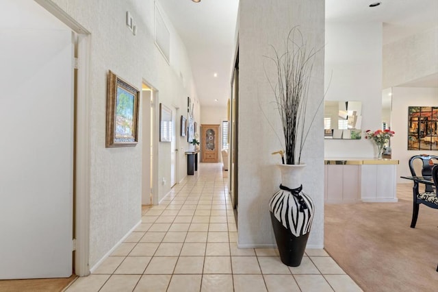 corridor with a high ceiling and light tile patterned floors