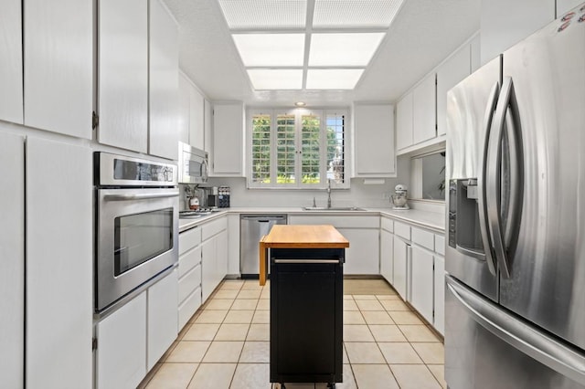 kitchen featuring stainless steel appliances, sink, and white cabinets