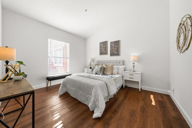 bedroom with dark wood-type flooring and lofted ceiling