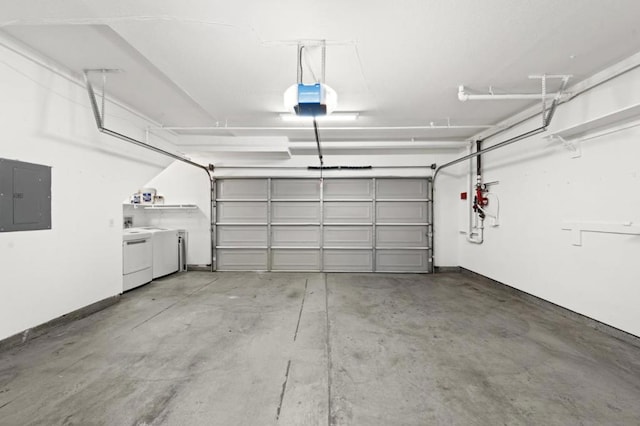 garage with a garage door opener, washing machine and clothes dryer, and electric panel