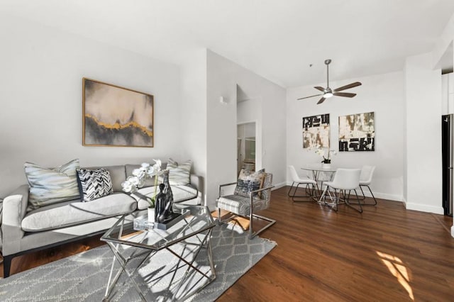 living room with dark wood-type flooring and ceiling fan