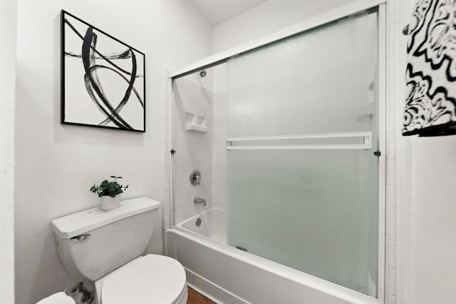 bathroom with bath / shower combo with glass door and toilet