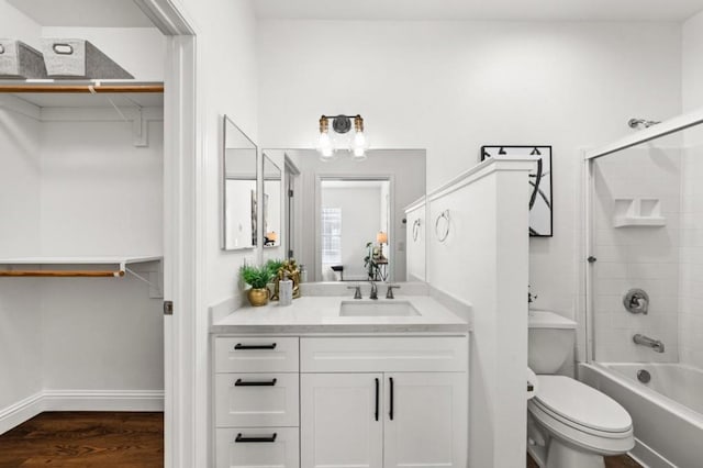 full bathroom featuring wood-type flooring, toilet, vanity, and tiled shower / bath