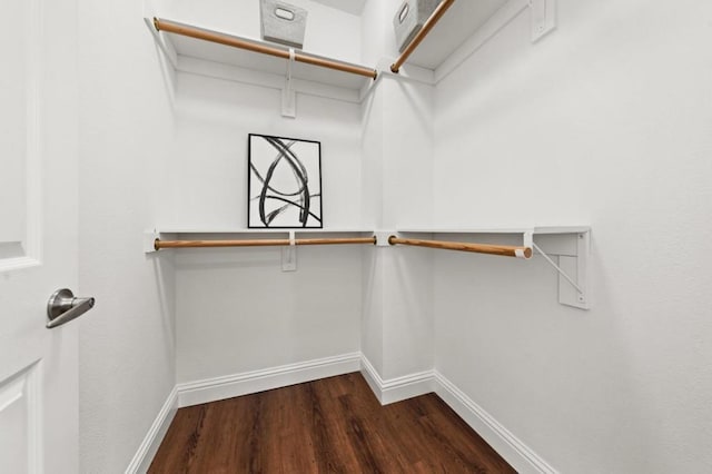 walk in closet with dark wood-type flooring