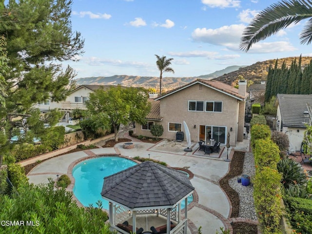 view of pool featuring a mountain view, a patio area, and a gazebo