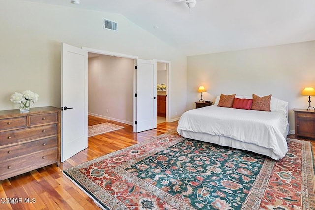 bedroom with light hardwood / wood-style flooring and lofted ceiling