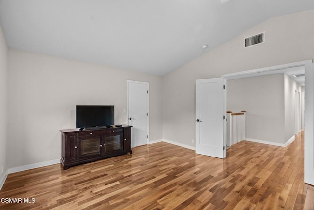 living room with light hardwood / wood-style flooring and vaulted ceiling