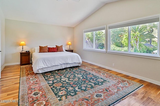 bedroom with vaulted ceiling and wood-type flooring