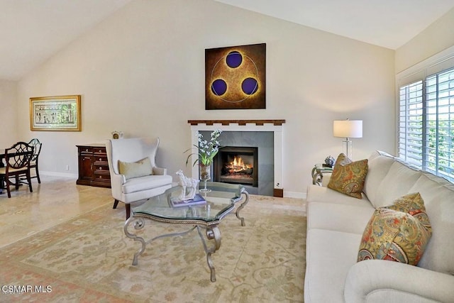 living room with vaulted ceiling and a tile fireplace