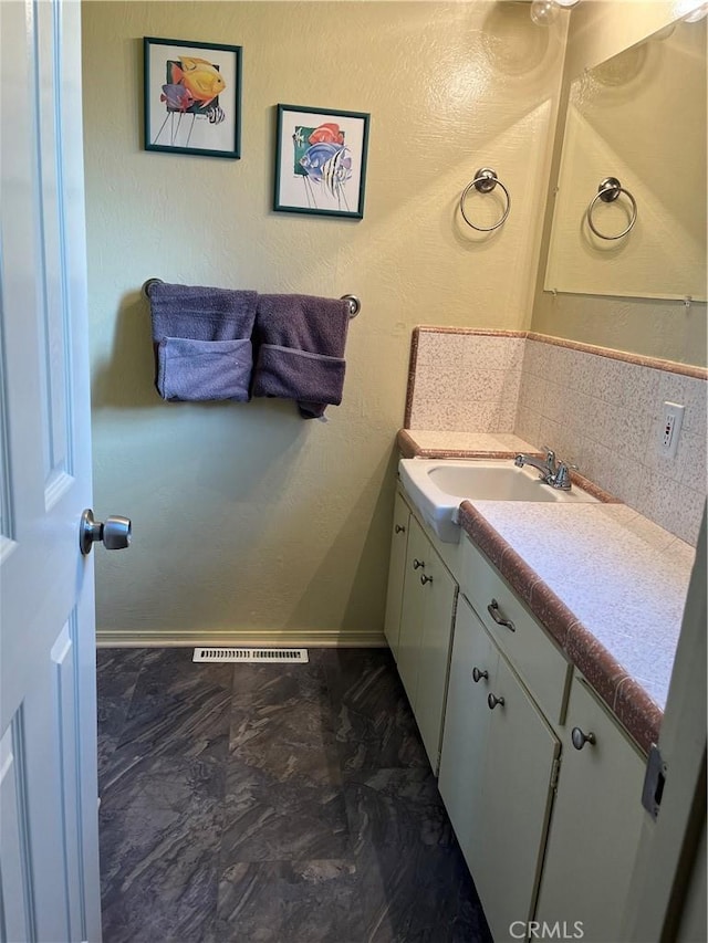 bathroom with tasteful backsplash and vanity