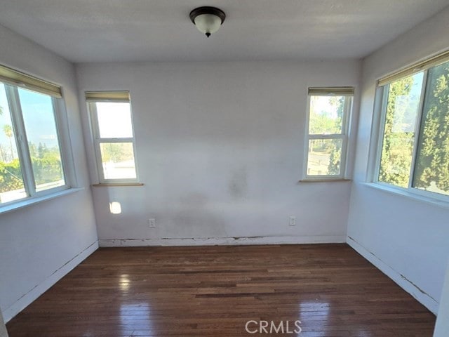 unfurnished room with dark hardwood / wood-style flooring