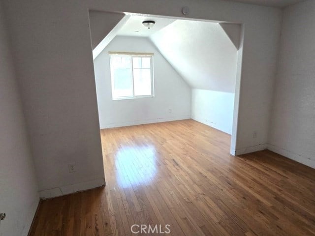 bonus room with lofted ceiling and wood-type flooring