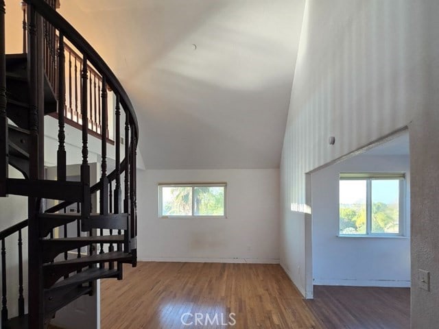 stairs with vaulted ceiling and hardwood / wood-style flooring