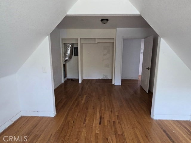 bonus room featuring a textured ceiling, dark wood-type flooring, and lofted ceiling