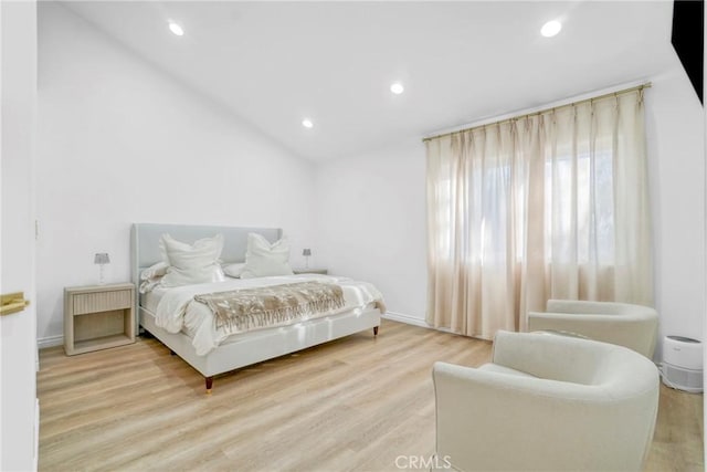 bedroom featuring light hardwood / wood-style floors and vaulted ceiling