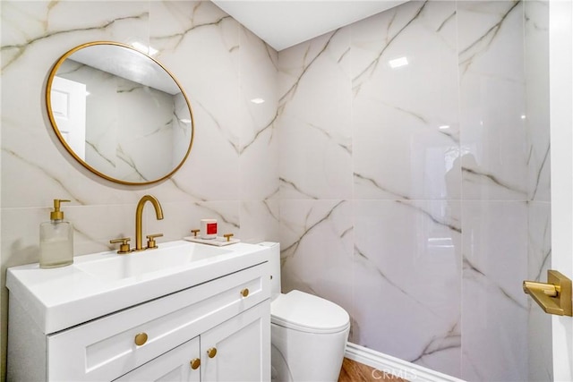 bathroom with tile walls, toilet, and vanity