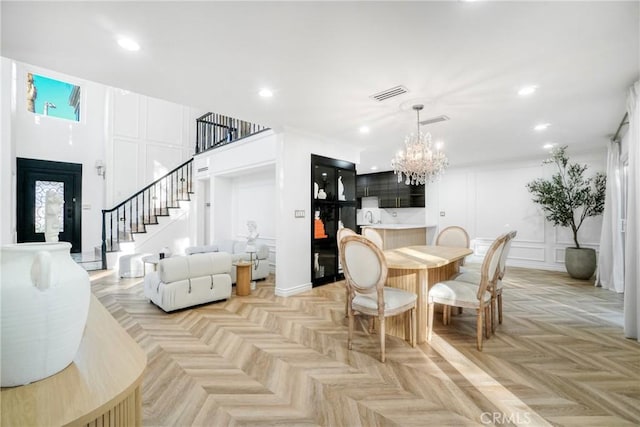 dining room with light parquet flooring and a chandelier