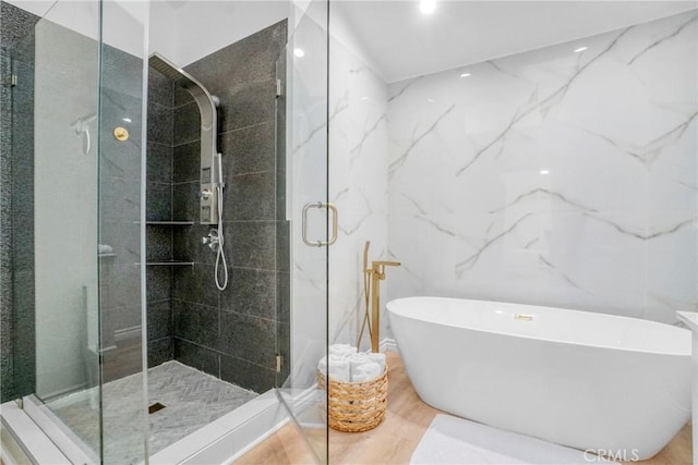 bathroom with tile walls and independent shower and bath