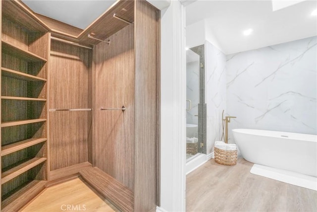 bathroom with hardwood / wood-style floors and independent shower and bath