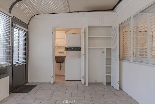 interior space with stacked washer / drying machine and sink