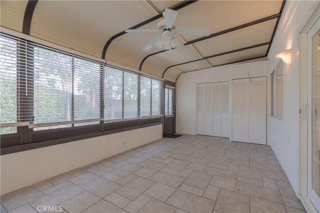 unfurnished sunroom with ceiling fan