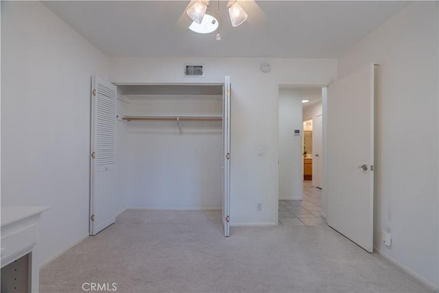 unfurnished bedroom with light colored carpet, a closet, and ceiling fan