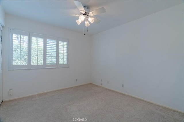 empty room with ceiling fan and light carpet