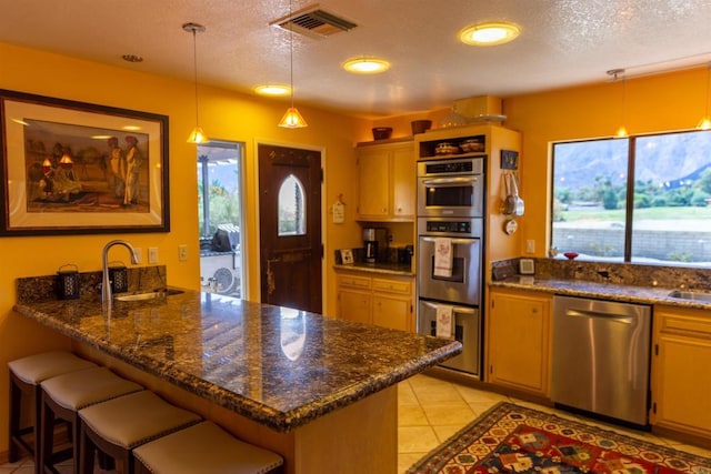 kitchen with a breakfast bar area, kitchen peninsula, sink, and stainless steel appliances