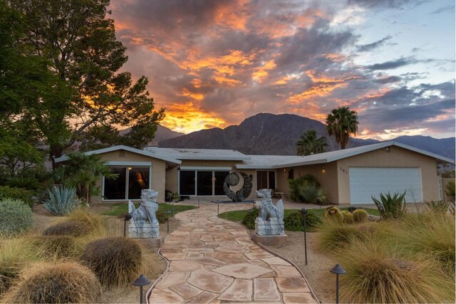 view of front of home with a garage and a mountain view